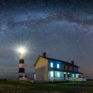 A lighthouse at night with Milky Way above